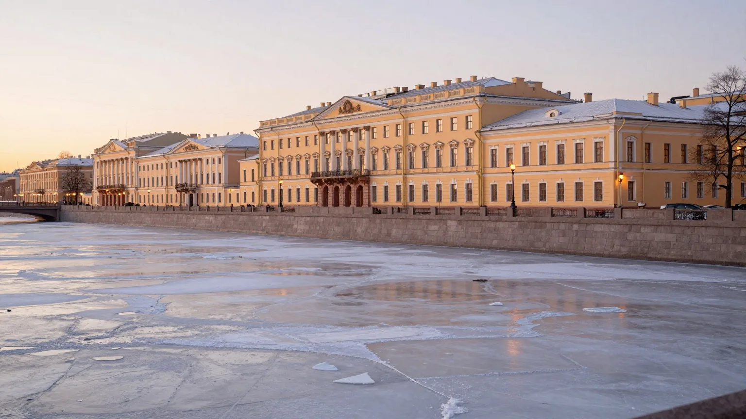 Eine winterliche Uferstraße in Sankt Petersburg mit Pastellfassaden, Eisschollen und Lampenlicht am Granitkai