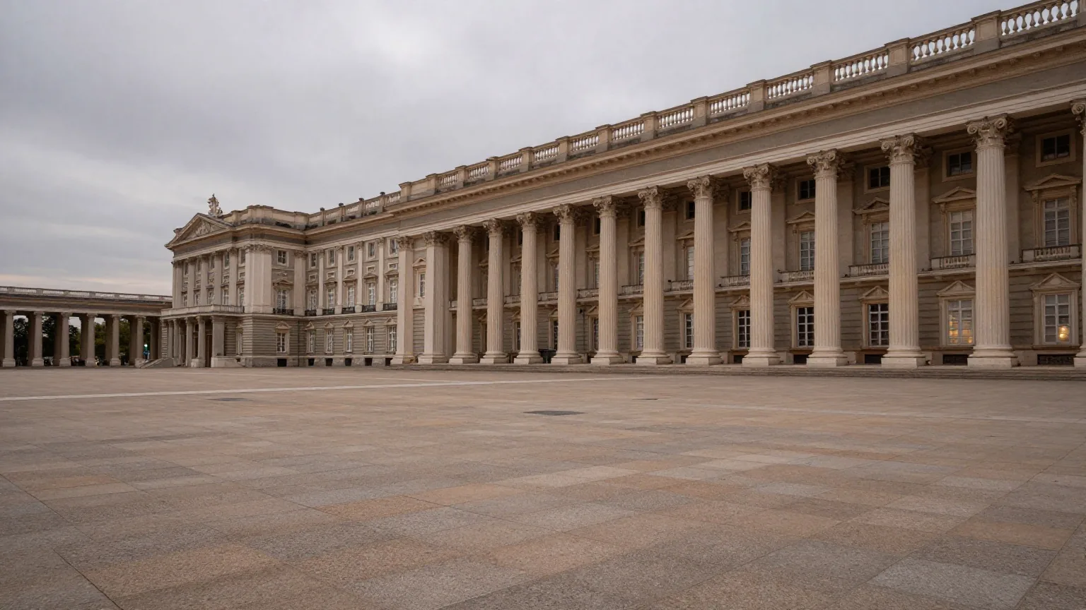 Ein leerer klassizistischer Regierungspalast mit langer Säulenreihe in der Dämmerung vor einem weiten leeren Platz
